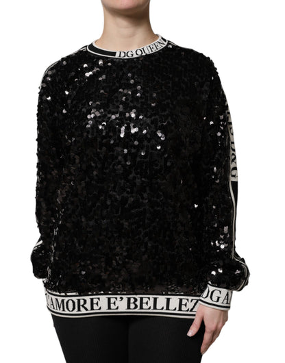 Black sequin glitter top viewed from the front, with text details on collar and hem.