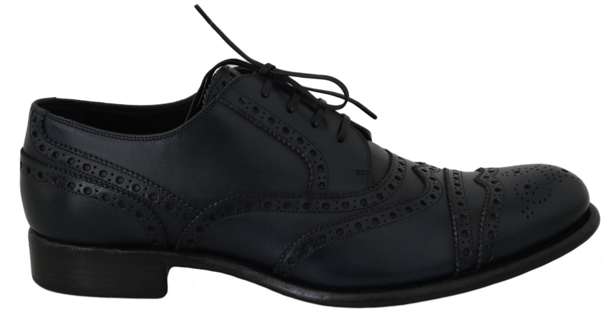 Black lace-up shoe viewed from the side with brogue detailing and low heel
