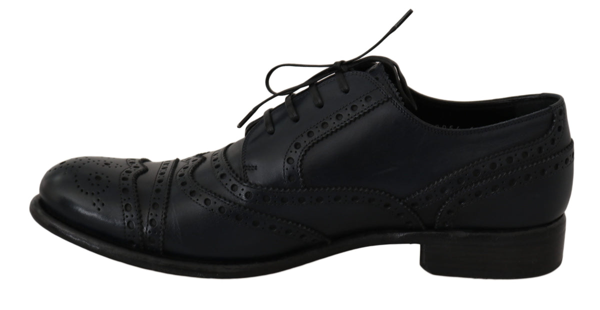 Black lace-up shoe viewed from the side with decorative perforations and brogue detailing.