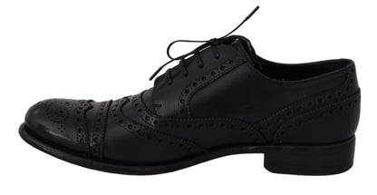 Black lace-up shoe viewed from the side with decorative perforations and brogue detailing.