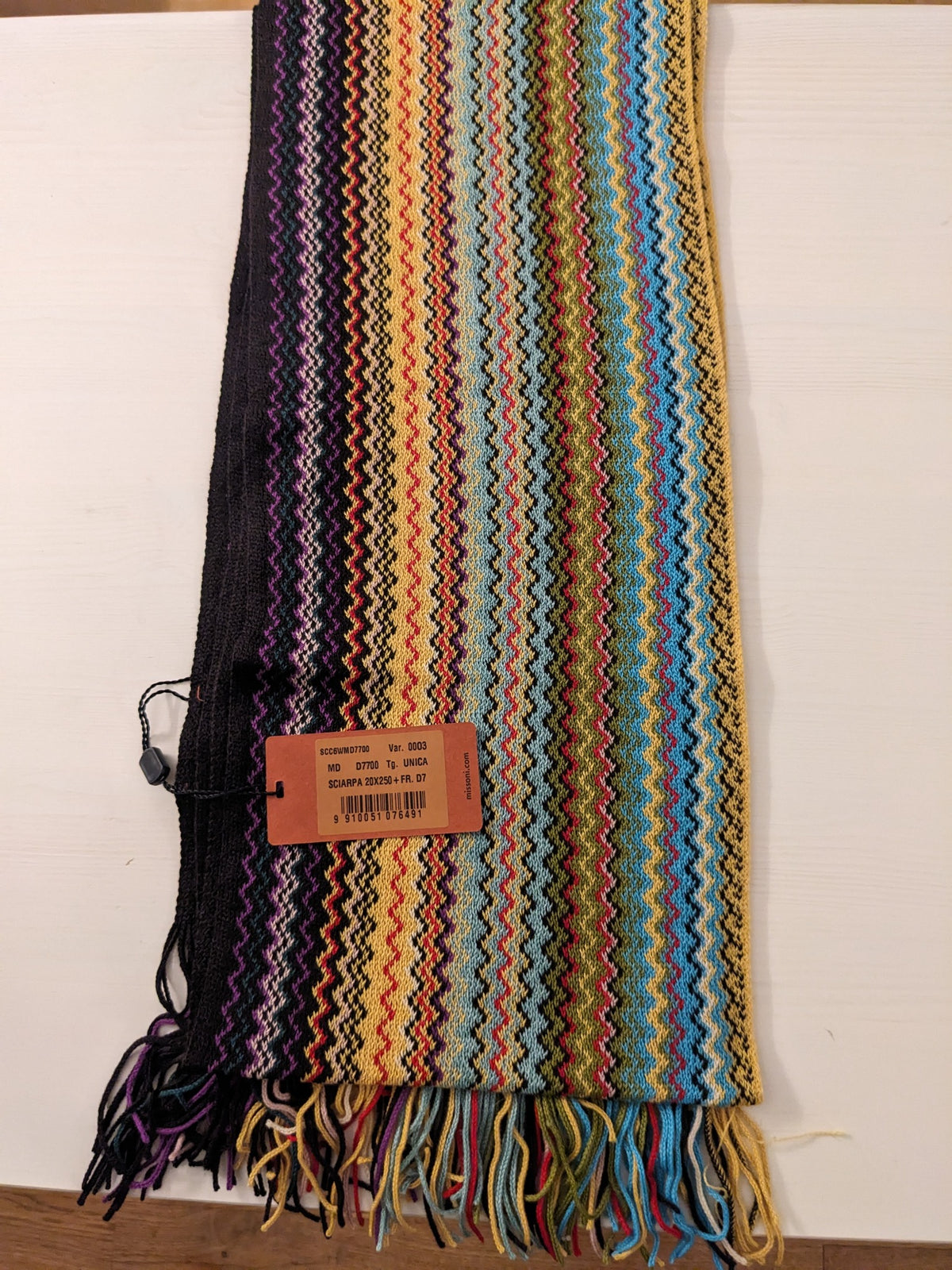 Missoni scarf folded with zigzag stripes in blue, yellow, red, green, purple and black